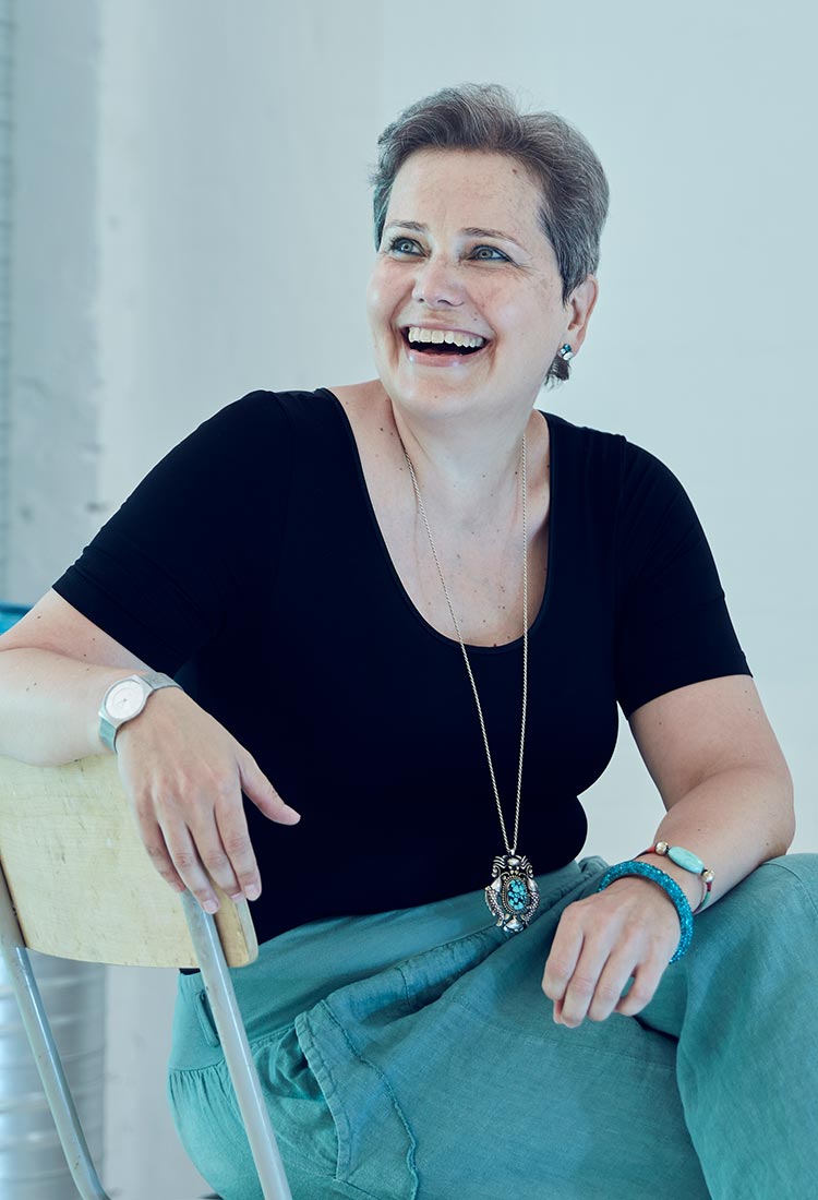 Barbara Diehl lachend auf einem Stuhl sitzend, Foto: SPRIND GmbH
