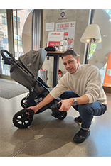 Mann kniet voer Kinderwagen