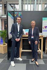 Zwei Personen vor Stellwand