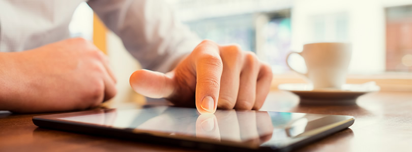 Person with tablet PC and coffee mug