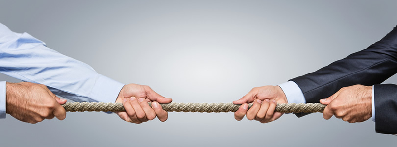 Two men pulling a rope in different directions