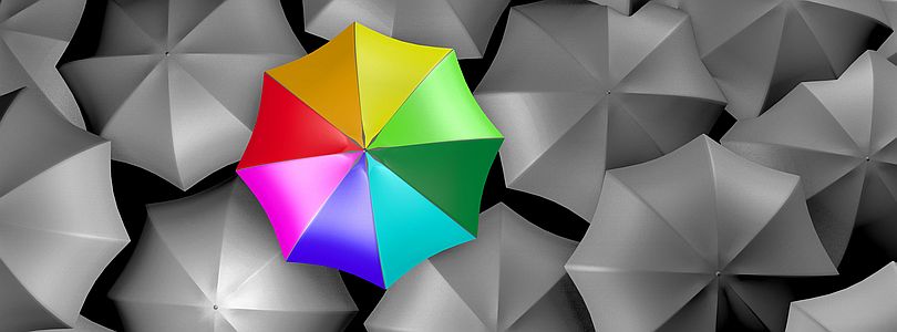A colourful umbrella amidst grey ones