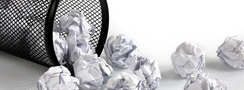 Toppled bin with crumbled sheets of paper