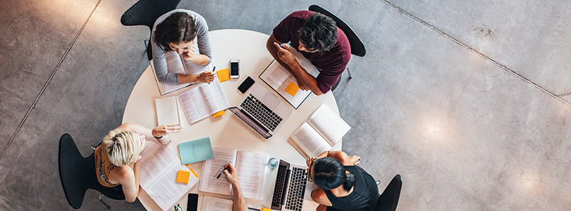 4 people working at a round table