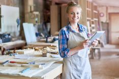 Frau in Schreinerei mit Tablet