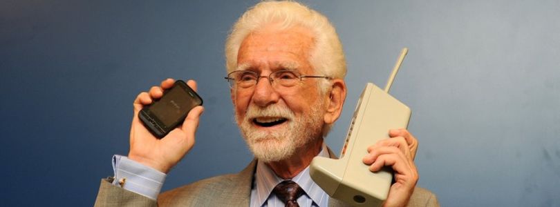 Martin Cooper with his historic prototype and a modern phone in 2009