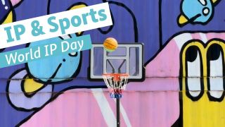 Ball fliegt auf Baketballkorb vor Wand mit Graffitis 